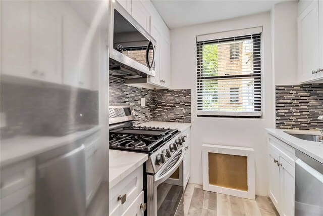 22-39 78th St Unit 2F, East Elmhurst, NY 11370 - kitchen with stainless steel appliances, decorative backsplash, white cabinets, and a sink