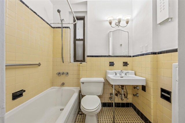398 Oliver Pl Unit 1A, Bronx, NY 10458 - bathroom with toilet,  shower combination, tile walls, a wainscoted wall, and a sink