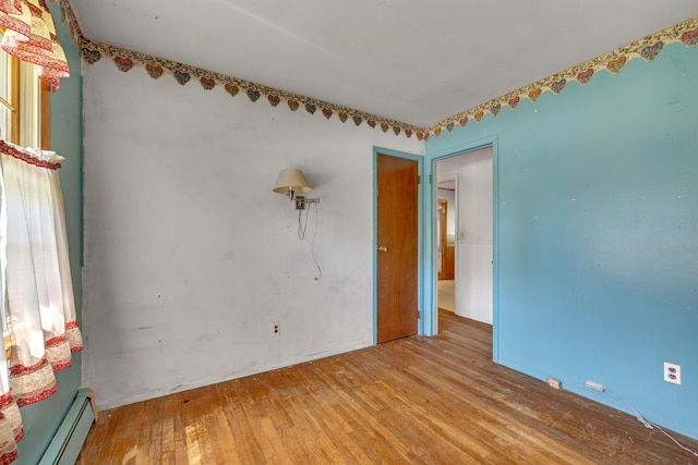 34 Leeside Dr, Carmel, NY 10512 - empty room with a baseboard heating unit and hardwood / wood-style floors