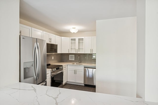 10-11 162nd St Unit 4A, Beechhurst, NY 11357 - kitchen featuring appliances with stainless steel finishes, a sink, tasteful backsplash, and white cabinetry