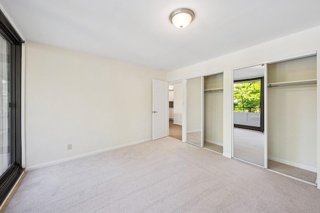 10-11 162nd St Unit 4A, Beechhurst, NY 11357 - unfurnished bedroom featuring two closets, carpet floors, and baseboards