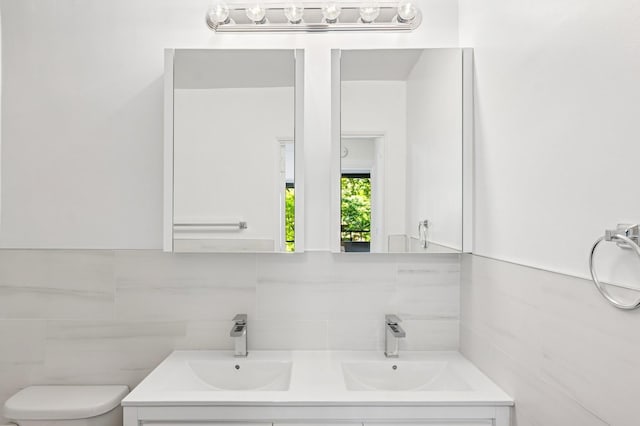 10-11 162nd St Unit 4A, Beechhurst, NY 11357 - bathroom with double vanity, tile walls, decorative backsplash, and toilet