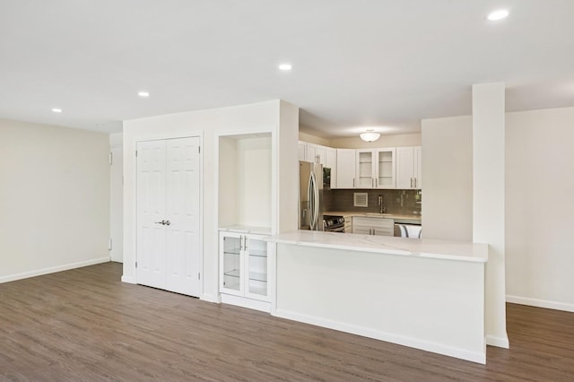 10-11 162nd St Unit 4A, Beechhurst, NY 11357 - kitchen with stainless steel appliances, glass insert cabinets, dark wood-style flooring, white cabinetry, and light countertops