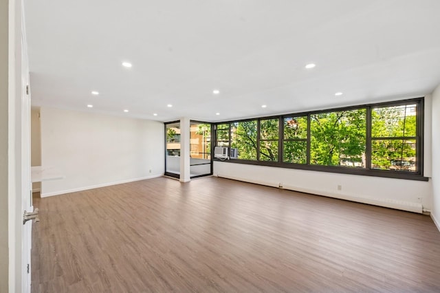 10-11 162nd St Unit 4A, Beechhurst, NY 11357 - empty room with plenty of natural light, recessed lighting, wood finished floors, cooling unit, and baseboards