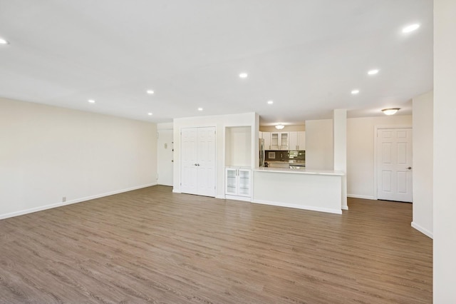 10-11 162nd St Unit 4A, Beechhurst, NY 11357 - unfurnished living room with wood finished floors, recessed lighting, and baseboards