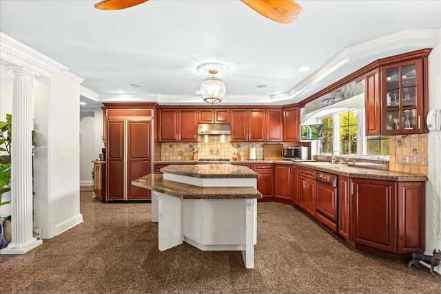 10 Bulaire, East Rockaway, NY 11518 - kitchen featuring under cabinet range hood, ornamental molding, a center island, stainless steel microwave, and glass insert cabinets