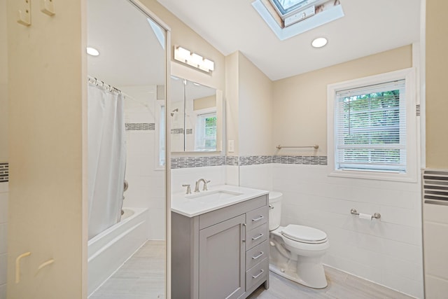1817 Lincoln Ave, Holbrook, NY 11741 - full bath featuring tile walls, a skylight, vanity, shower / tub combo, and wainscoting
