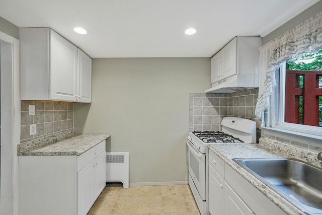 1817 Lincoln Ave, Holbrook, NY 11741 - kitchen with white gas range, under cabinet range hood, radiator heating unit, white cabinetry, and light countertops