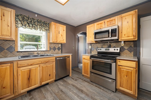 13 Cedar Ln, Poughkeepsie, NY 12601 - kitchen featuring appliances with stainless steel finishes, light wood-type flooring, arched walkways, and tasteful backsplash