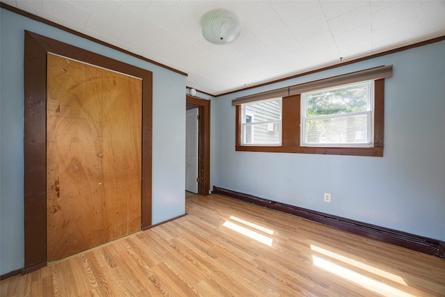13 Cedar Ln, Poughkeepsie, NY 12601 - unfurnished bedroom featuring ornamental molding, light wood-style flooring, and a closet