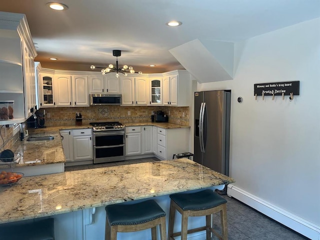 14 Cornfield Ln, Commack, NY 11725 - kitchen featuring appliances with stainless steel finishes, a baseboard radiator, a peninsula, glass insert cabinets, and recessed lighting