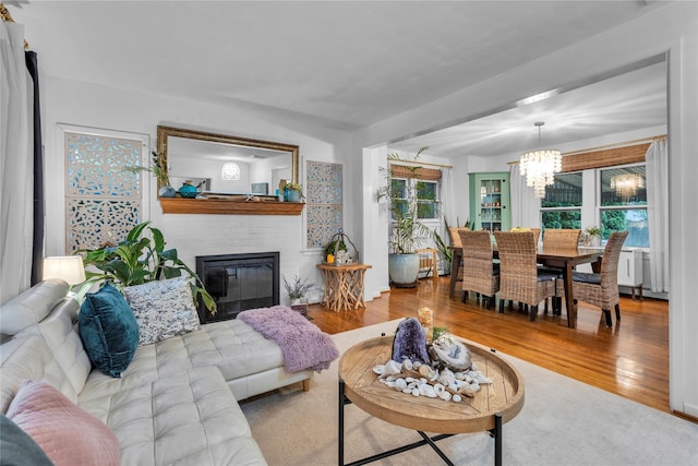 123 Maple Ave, Northport, NY 11768 - living room with a chandelier, wood finished floors, and a fireplace