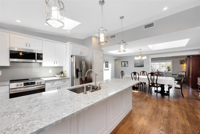 18 Hamilton St, Farmingdale, NY 11735 - kitchen with appliances with stainless steel finishes, a skylight, a sink, white cabinets, and recessed lighting