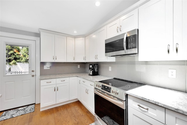 18 Hamilton St, Farmingdale, NY 11735 - kitchen with stainless steel appliances, white cabinets, light wood-style flooring, recessed lighting, and light stone countertops