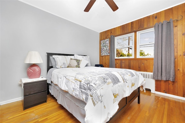 18 Hamilton St, Farmingdale, NY 11735 - bedroom featuring radiator heating unit, baseboards, wood walls, wood finished floors, and crown molding