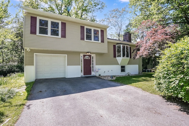 7 Adele Ct, Montrose, NY 10567 - split level home featuring a garage, driveway, and a chimney