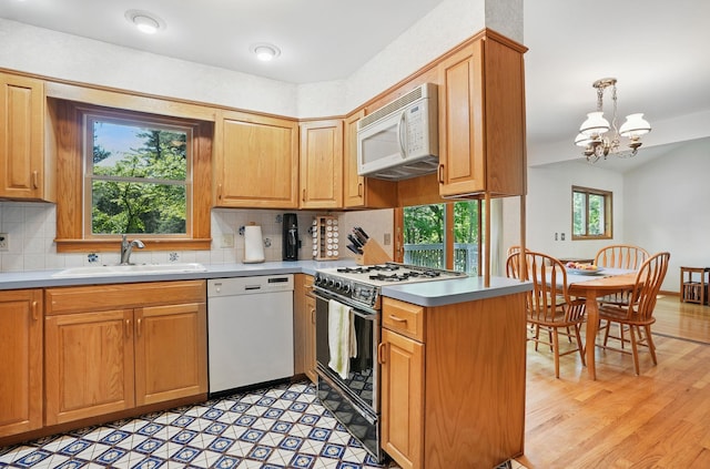 7 Adele Ct, Montrose, NY 10567 - kitchen featuring white appliances, a sink, a chandelier, a peninsula, and backsplash