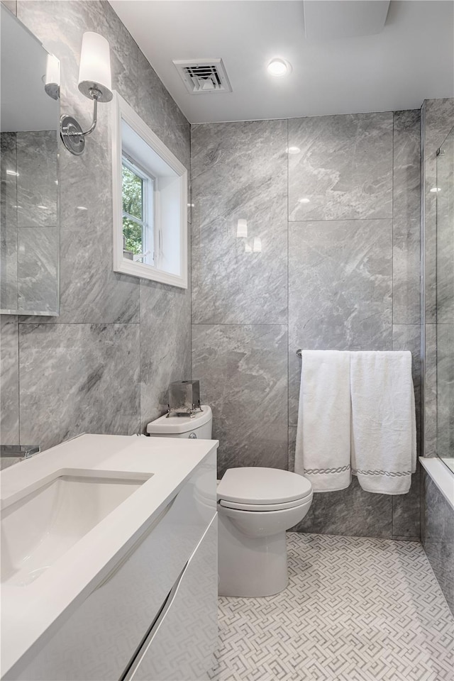 2740 Netherland Ave, Bronx, NY 10463 - full bathroom featuring tile walls, toilet, tiled shower, and vanity