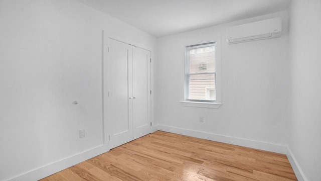 3964 Duryea Ave, Bronx, NY 10466 - unfurnished bedroom with a wall mounted AC, baseboards, light wood-style floors, and a closet