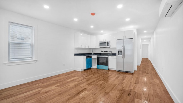 3964 Duryea Ave, Bronx, NY 10466 - kitchen featuring stainless steel appliances, a wall mounted air conditioner, white cabinetry, dark countertops, and baseboards