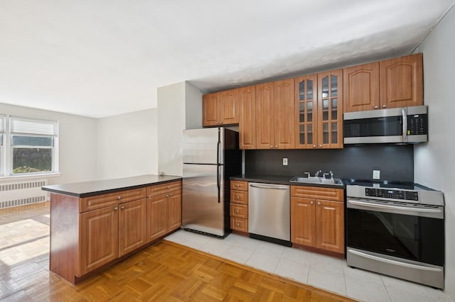 162-21 Powells Cove Blvd Unit 1M, Beechhurst, NY 11357 - kitchen with stainless steel appliances, radiator, a peninsula, and dark countertops