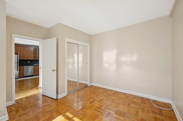 162-21 Powells Cove Blvd Unit 1M, Beechhurst, NY 11357 - unfurnished bedroom featuring baseboards, freestanding refrigerator, and a closet
