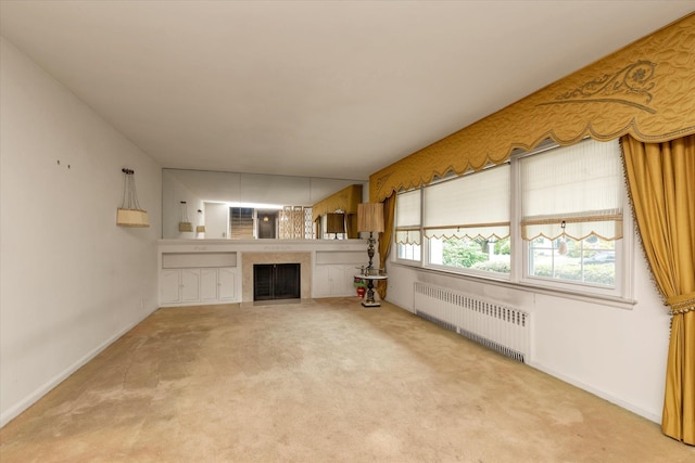 725 Clinton St, Westbury, NY 11590 - unfurnished living room featuring radiator heating unit, carpet flooring, baseboards, and a fireplace with flush hearth