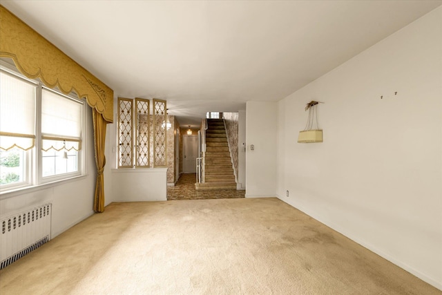725 Clinton St, Westbury, NY 11590 - carpeted empty room featuring radiator and stairs