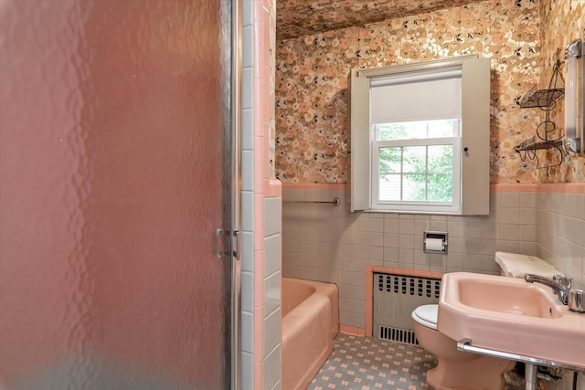 725 Clinton St, Westbury, NY 11590 - bathroom featuring radiator, tile walls, a tub, wainscoting, and toilet