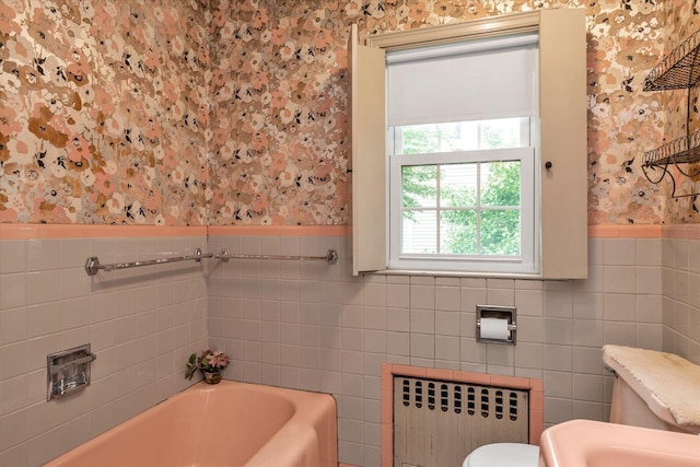725 Clinton St, Westbury, NY 11590 - full bathroom with radiator, wallpapered walls, tile walls, a tub to relax in, and a wainscoted wall