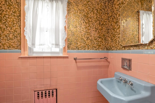 725 Clinton St, Westbury, NY 11590 - bathroom with wallpapered walls, a sink, radiator, wainscoting, and tile walls