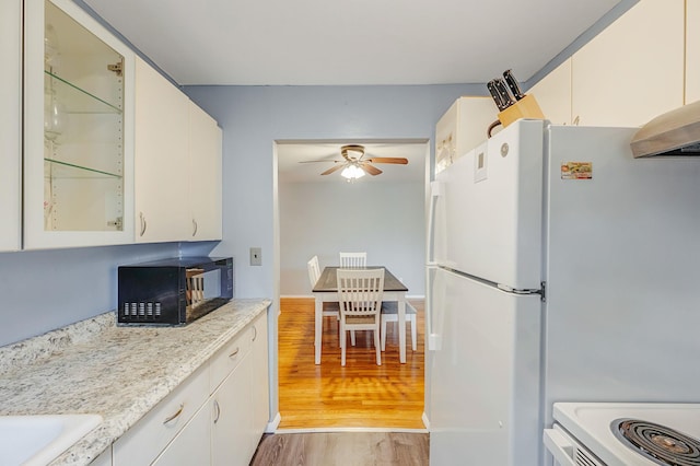 2453 Union Blvd Unit 37A, Islip, NY 11751 - kitchen with black microwave, light wood-type flooring, ceiling fan, glass insert cabinets, and freestanding refrigerator