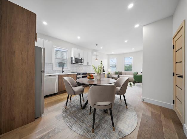 14-09 131st St, College Point, NY 11356 - dining room with healthy amount of natural light, recessed lighting, light wood-style flooring, and baseboards