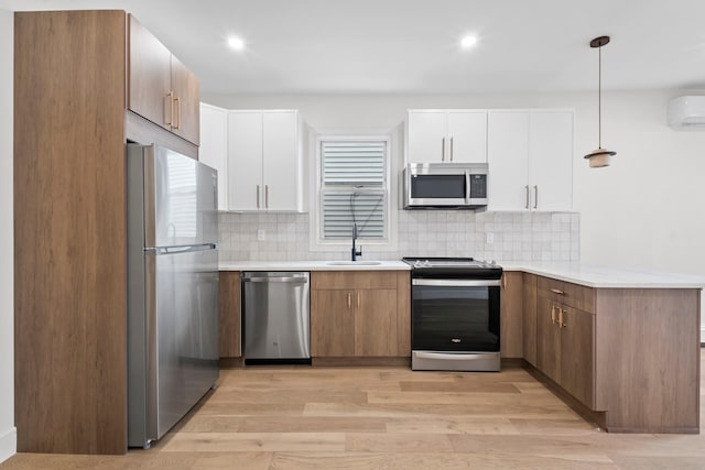 14-09 131st St, College Point, NY 11356 - kitchen featuring stainless steel appliances, a sink, light wood-style floors, tasteful backsplash, and a peninsula
