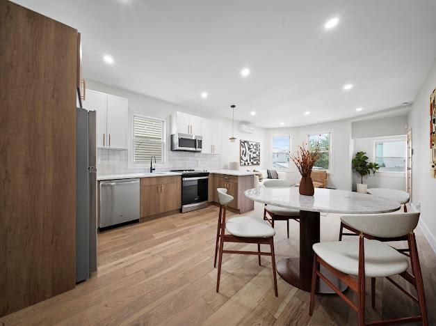 14-09 131st St, College Point, NY 11356 - kitchen featuring stainless steel appliances, a sink, light wood-style floors, plenty of natural light, and recessed lighting