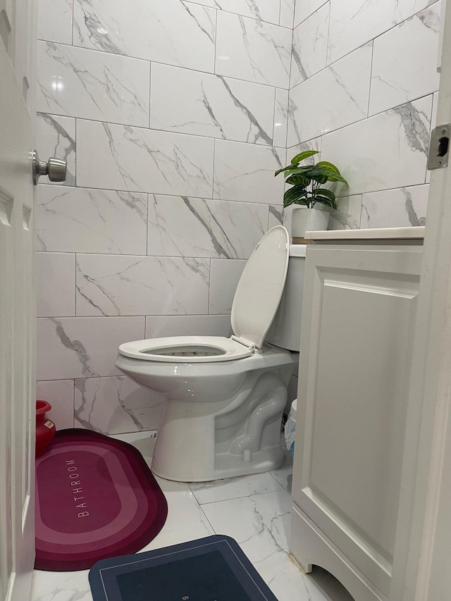 17363 105th Ave, Jamaica, NY 11433 - half bathroom featuring marble finish flooring, toilet, and tile walls