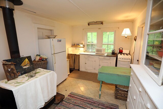 12 Henderson Rd, Hankins, NY 12741 - kitchen with white appliances, light flooring, white cabinetry, and a wood stove