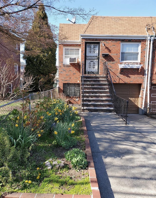 7345 53rd Rd, Maspeth, NY 11378 - view of front of home with brick siding, a garage, roof with shingles, and fence
