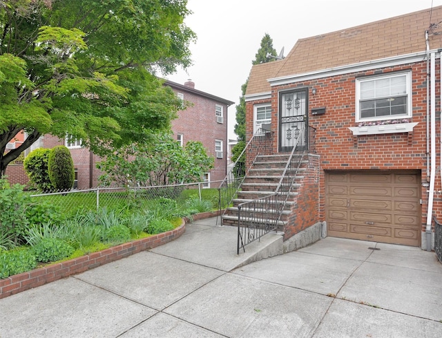 7345 53rd Rd, Maspeth, NY 11378 - view of front of property with brick siding, a garage, fence, a shingled roof, and driveway