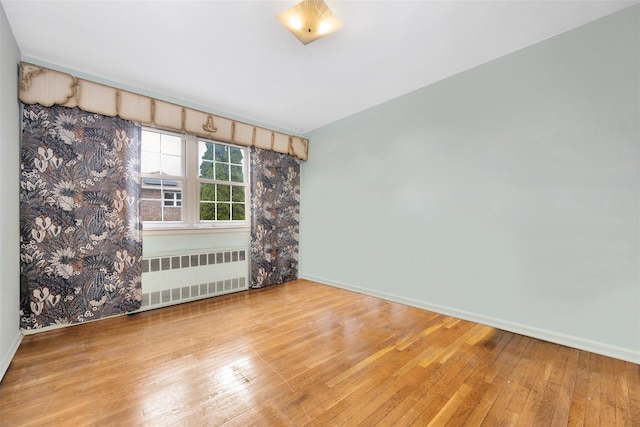 7345 53rd Rd, Maspeth, NY 11378 - spare room with radiator heating unit, wood-type flooring, and baseboards