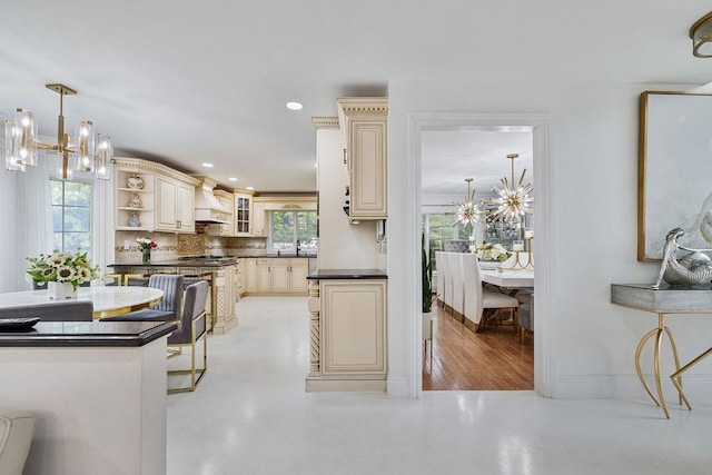 8 Stark Ct, New City, NY 10956 - kitchen with cream cabinets, a chandelier, dark countertops, tasteful backsplash, and glass insert cabinets
