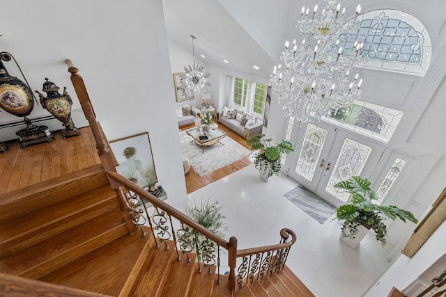 8 Stark Ct, New City, NY 10956 - stairs featuring a chandelier, high vaulted ceiling, wood finished floors, french doors, and recessed lighting