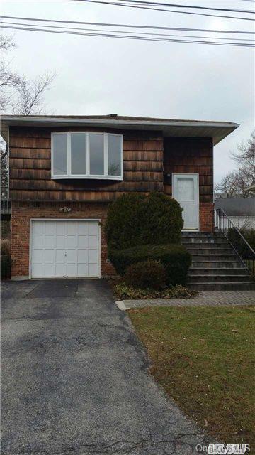 10 Murray St, Bayville, NY 11709 - view of front of house featuring driveway, a garage, and brick siding