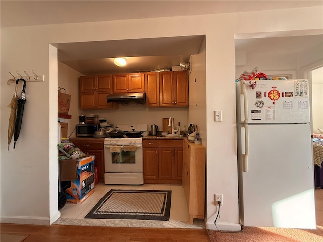 5803 Calloway St Unit 5A, Corona, NY 11368 - kitchen featuring white appliances, under cabinet range hood, brown cabinets, and a sink