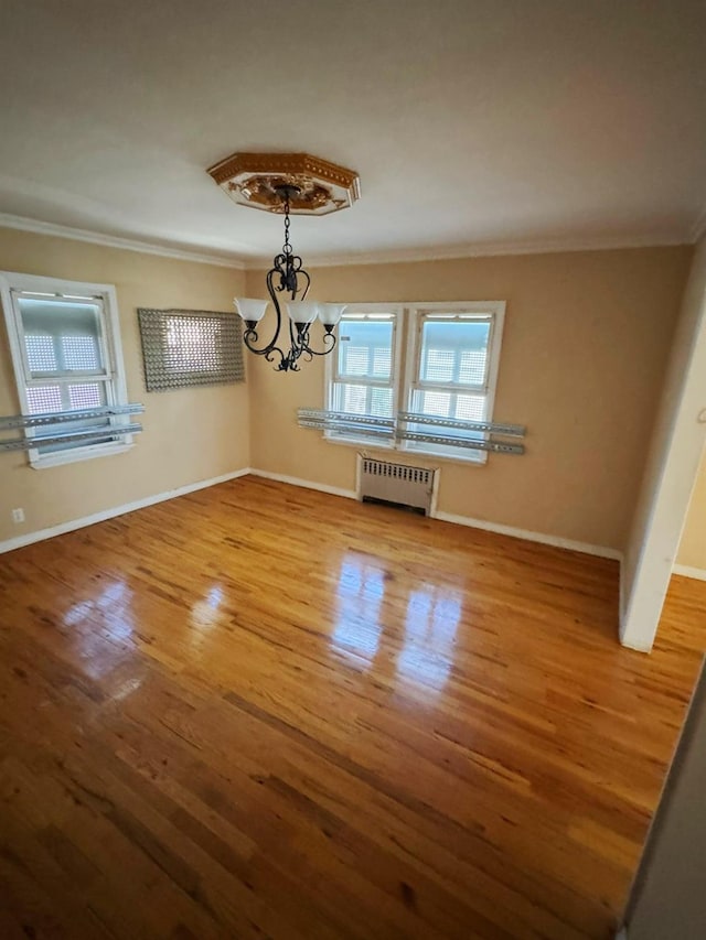 186-39 Ilion Ave, Saint Albans, NY 11412 - unfurnished dining area featuring radiator, ornamental molding, wood finished floors, a chandelier, and baseboards