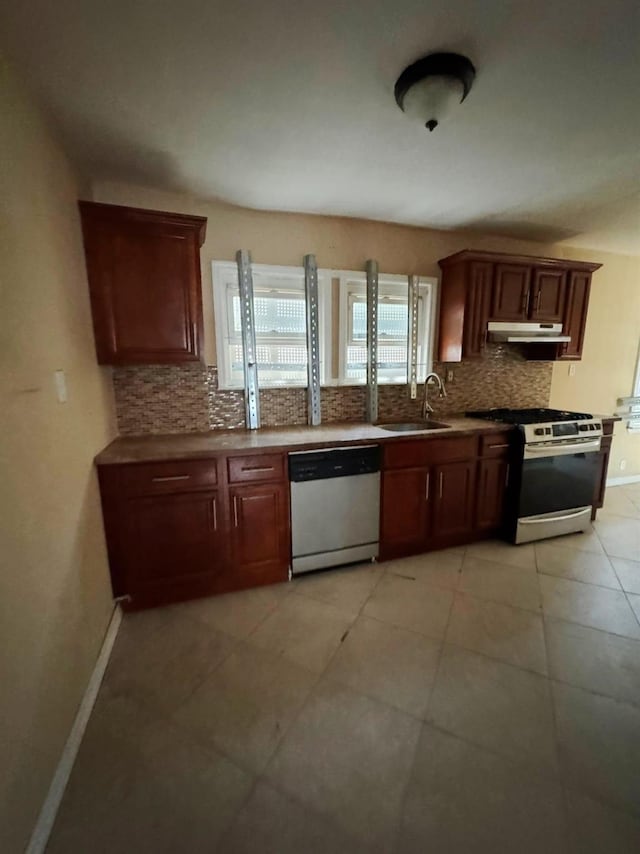 186-39 Ilion Ave, Saint Albans, NY 11412 - kitchen featuring appliances with stainless steel finishes, under cabinet range hood, a sink, decorative backsplash, and baseboards