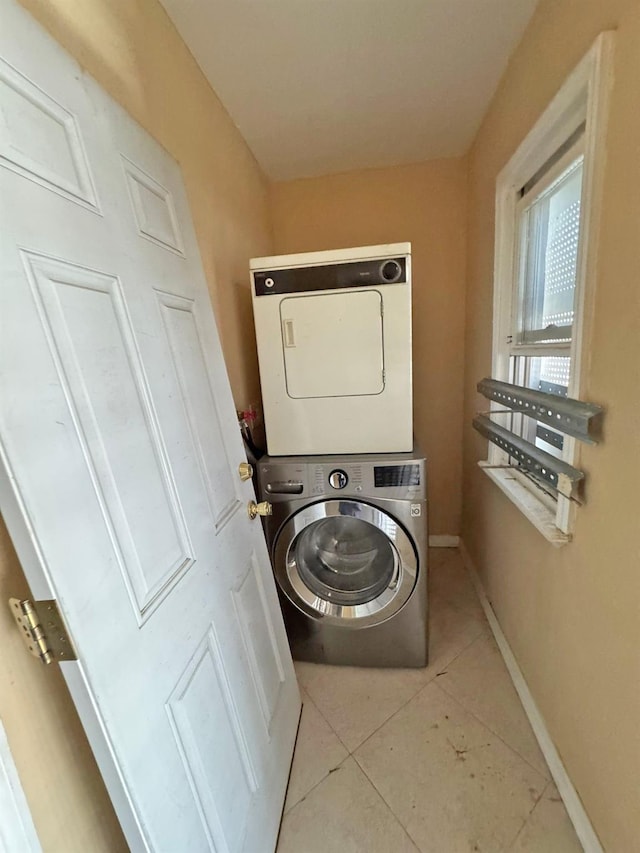186-39 Ilion Ave, Saint Albans, NY 11412 - laundry room with stacked washer / drying machine, light tile patterned floors, and baseboards