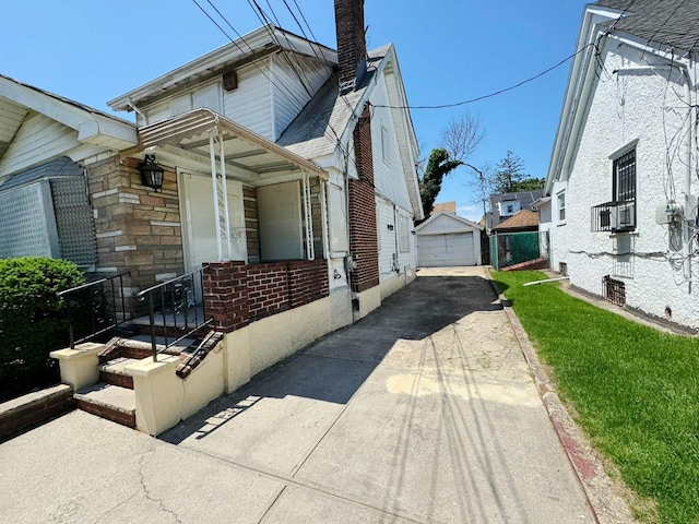 186-39 Ilion Ave, Saint Albans, NY 11412 - view of property exterior featuring driveway, a detached garage, a chimney, an outdoor structure, and brick siding