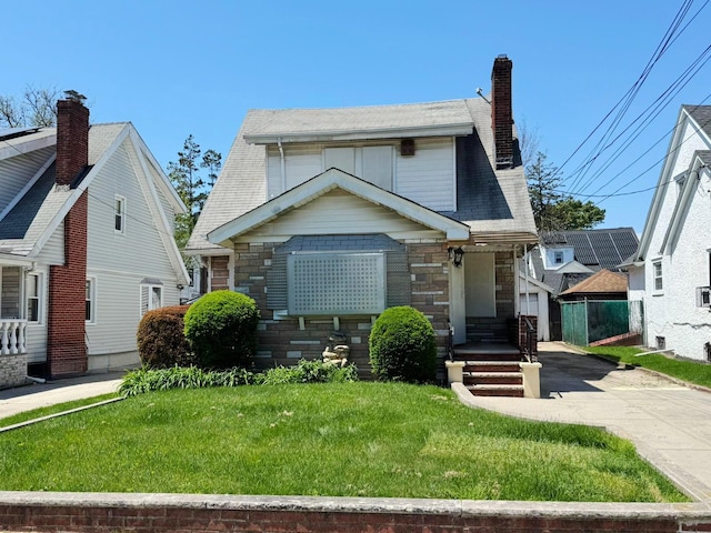 186-39 Ilion Ave, Saint Albans, NY 11412 - view of front of property with a chimney, a front yard, and stone siding