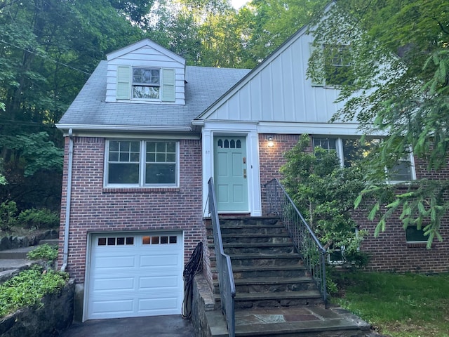 87 Cliff St, Hastings-On-Hudson, NY 10706 - view of front of property with brick siding, an attached garage, and board and batten siding